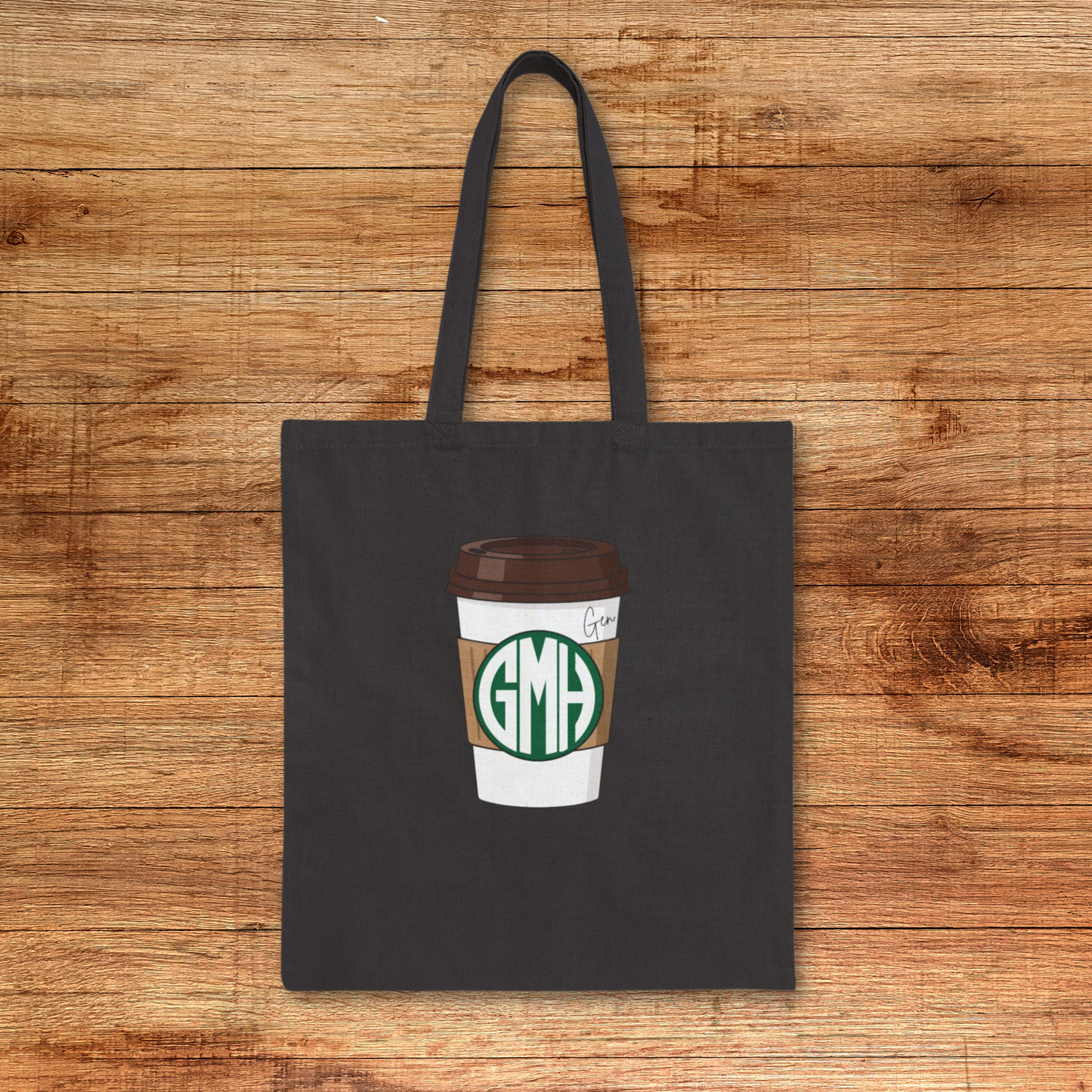 Super simple cotton canvas tote bag with a coffee shop (you know who) style monogram on a to go cup. A name or phrase like "The Charlie" or Pumpkin Spice Latte is also written to the top right. No boxed corners, just a bold monogram on your choice of natural or black canvas bag. 